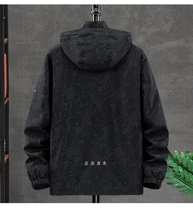 Detail view of men's hooded jacket back with tropical leaf pattern and functional icons
