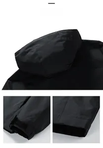 Detail view of black hooded jacket featuring adjustable velcro cuffs and windproof fabric