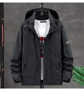 Close-up of windproof grey jacket featuring a subtle palm leaf pattern and hooded collar