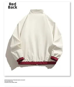 Vue détaillée du dos de la veste réversible en crème avec bordures élastiques rouges