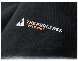 Detail of windproof black fabric with leaf texture and mountain climber logo on jacket