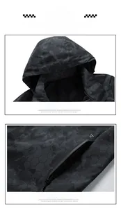 Detail of waterproof zippers and honeycomb camo texture on dark gray outdoor jacket