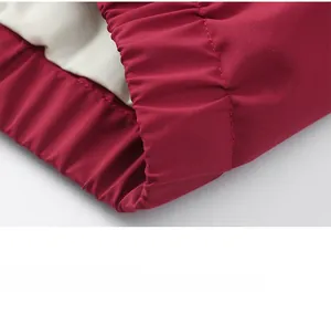 Détail de l'ourlet élastique et des coutures sur une veste réversible rouge pour hommes