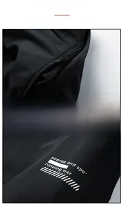 Detail view of the detachable hood zipper and sleeve letter printing on a black jacket