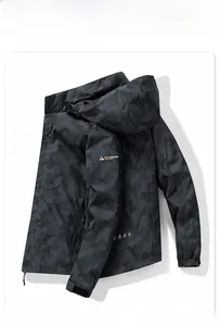 Detail of black camo hooded outdoor jacket with logo patch and velcro adjustable cuffs