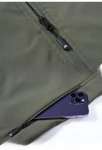 Detail of army green fishing vest featuring a durable AK logo zipper and a large side pocket
