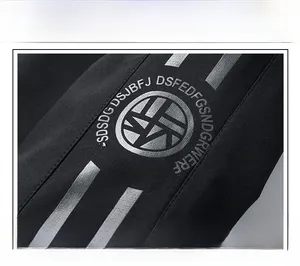 Detail of silver screen-printed logo and textured fabric on a black men's jacket sleeve