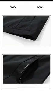 Detail of jacket hem and zipper pocket with RUN ING print on black functional fabric