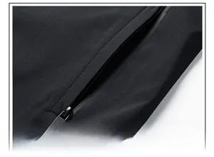 Macro detail of men's black jacket featuring a waterproof zippered pocket with fashion logo