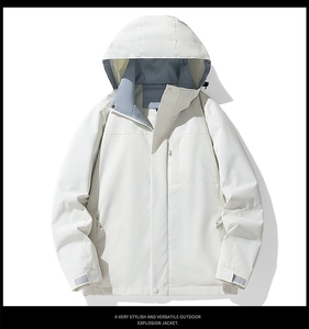 Detail of adjustable velcro cuffs and functional zipper pockets on a white outdoor jacket