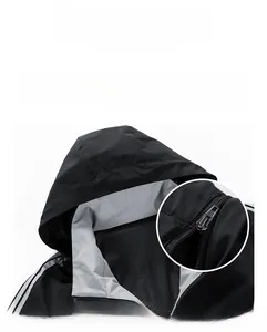 Detail of windproof outdoor jacket featuring a detachable hood and adjustable high-stand collar