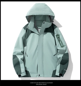 Detail view of waterproof zipper pocket and velcro cuff on green outdoor jacket
