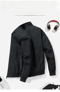 Close-up of black men's bomber jacket with detailed leaf texture and ribbed cuffs