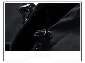 Detail of adjustable elastic drawstring hood with toggle on black windproof jacket