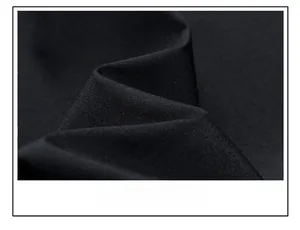 Close-up detail of smooth black woven fabric texture on a warm fleece hooded jacket