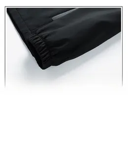 Detail of elastic cuff and zipper pocket on a black outdoor windbreaker jacket