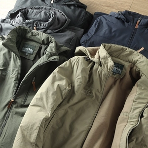 Détails de la veste outdoor imperméable avec doublure polaire et logo montagne brodé