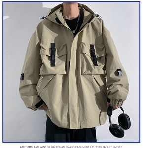 Close-up of khaki utility jacket featuring functional pockets and black buckle straps