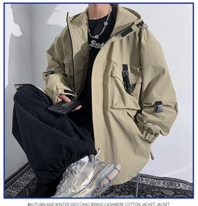 Detail of khaki hooded utility jacket featuring black tactical buckle straps and pockets