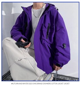 Detail of purple hooded utility jacket featuring multi-pocket design and strap accents