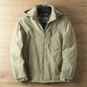 Détail de la veste outdoor montrant le logo montagne brodé et la poche zippée verticale