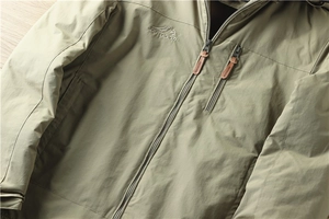 Détail de la broderie OUTDOOR et tirette en cuir sur la veste d'extérieur kaki