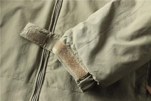 Détail de la veste outdoor vert armée avec poignets velcro et fermeture éclair métallique