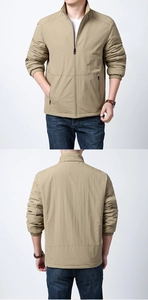 Detailed close-up of khaki outdoor jacket featuring stand collar and metal zipper pockets