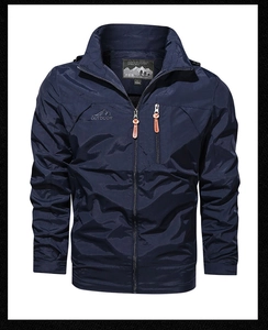 Macro detail of dark blue men's outdoor jacket with zipper pocket and mountain logo