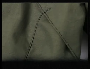 Close-up of olive green outdoor jacket showing high-quality stitching and fabric texture