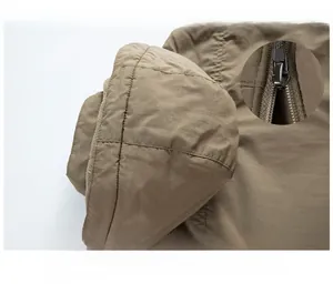 Dettaglio giacca kaki con cappuccio staccabile e chiusura con cerniera in metallo