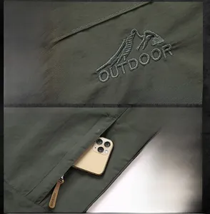 Detail of outdoor jacket showing mountain embroidery and a functional zipper pocket