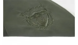 Detail shot of army green outdoor jacket featuring shield badge and outdoor embroidery