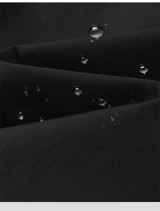 Macro detail of black water-resistant fabric with beads of water on matte texture