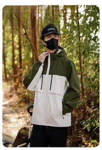 Detail of hooded windbreaker featuring olive green color-blocking and zip pockets
