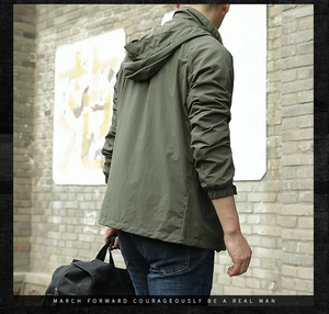 Detail of army green windproof jacket featuring elastic cuffs and functional side pockets