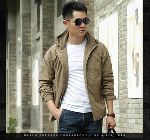 Detail of khaki outdoor jacket with stand-up collar and textured fabric on street background