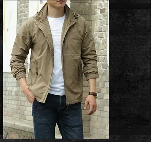 Detail of khaki outdoor hooded jacket featuring side zipper pockets and sleeve badge