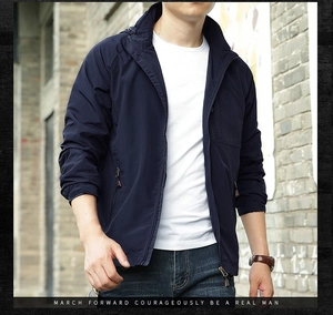 Detail of navy blue hooded outdoor jacket featuring premium zippers and functional pockets