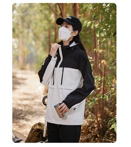 Detail view of the waterproof two-tone jacket with vertical chest pockets and hood