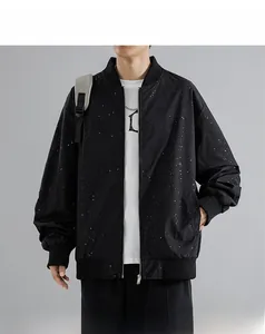 Close-up of black bomber jacket with white star splatter print and ribbed cuffs