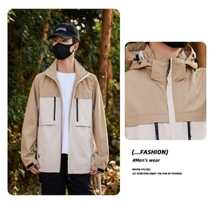 Detail of outdoor windbreaker jacket featuring waterproof pockets and adjustable hood