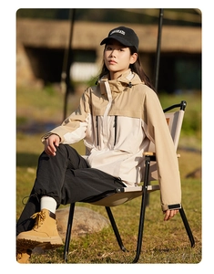 Detail of color-block windproof outdoor jacket with adjustable hood and zip pockets