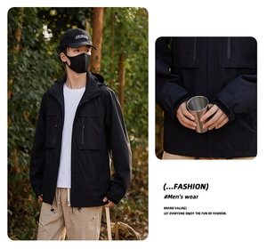 Detail of black windproof outdoor jacket featuring multiple functional zipper pockets