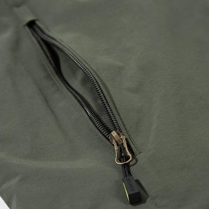 Close-up of olive green outdoor windbreaker showing ripstop fabric and zipper detail