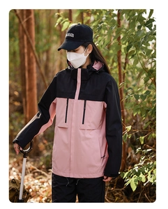 Close-up of pink and black color-block hiking jacket with functional zipper pockets