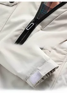Detail of metal zipper, classic plaid lining and adjustable velcro cuffs on jacket