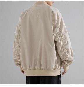Detail of light khaki bomber jacket featuring shimmering rhinestone embellishments on back