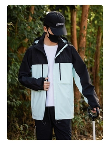 Outdoor model wearing a light breathable two-tone colorblock windbreaker with a hood