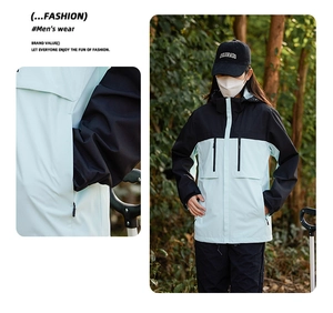 Detail view of water-resistant light blue and black color-block jacket with zipper pockets